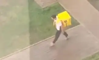 Молодой курьер в Астане: как дождь не остановил работу подростка с ноутбуком