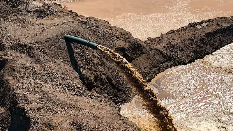 Из трубы идет грязная вода после очистки дна Астаниннского водохранилища 