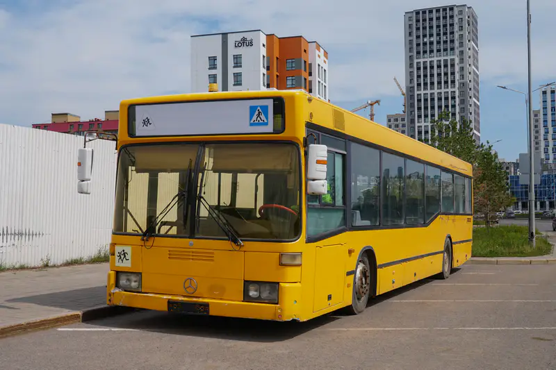 Старый жёлтые автобус постоянно стоит на обочине в Астане