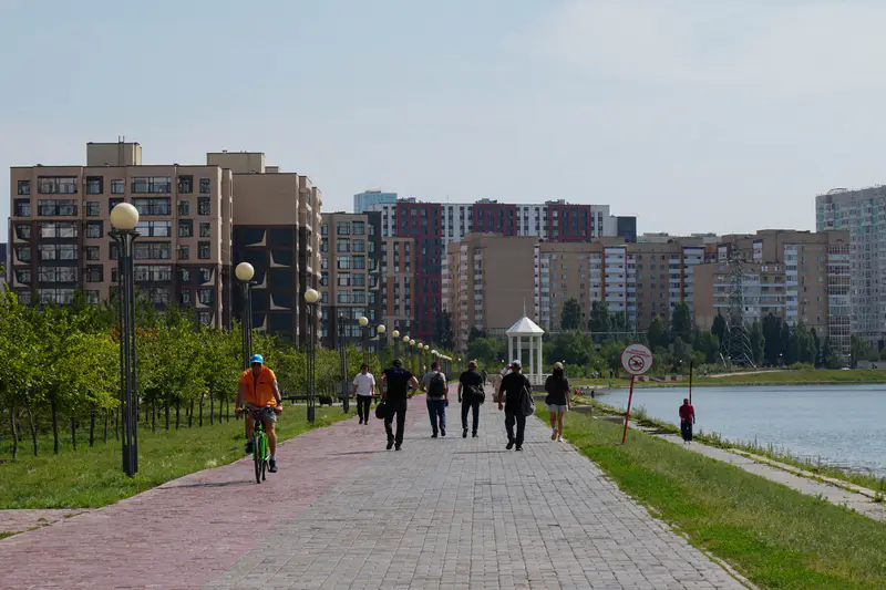 Люди идут по набережной Астаны