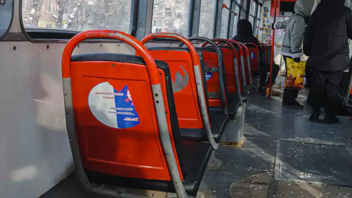 Ободранные наклейки с портретом и цитатами Абая в трамвае Усть-Каменогорска
